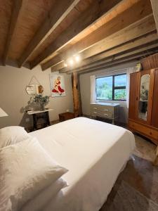 a bedroom with a large white bed and a window at De Oude Mayde in Wilderness