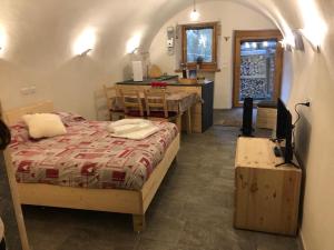 a bedroom with a bed and a kitchen with a table at Chalet Sweet Mountain in Ponte di Legno