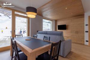 a dining room with a table and a couch at Radici Relais Sulle Piste da sci vicino a Lupigno in Livigno