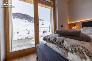 a bedroom with a window with a view of a beach at Radici Relais Sulle Piste da sci vicino a Lupigno in Livigno