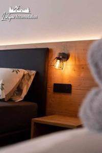 a room with a bed with a lamp and a table at Radici Relais Sulle Piste da sci vicino a Lupigno in Livigno