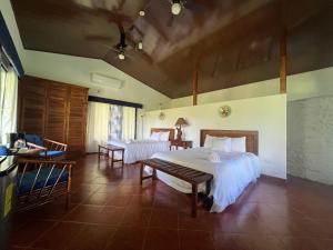 um quarto com duas camas e uma mesa em Blue Banyan Inn em Quepos