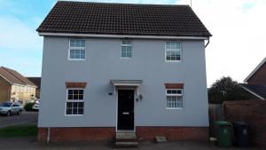 una casa blanca con una puerta negra en una calle en Amama's Cabin, en Great Yarmouth