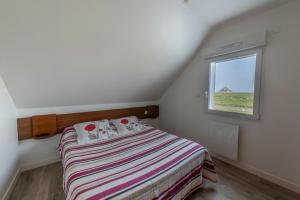 a small bedroom with a bed and a window at Etoile des Grèves in Ardevon