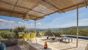 eine Terrasse mit einem Tisch und Stühlen sowie Aussicht in der Unterkunft l'Atelier des Milles Roches in Gordes