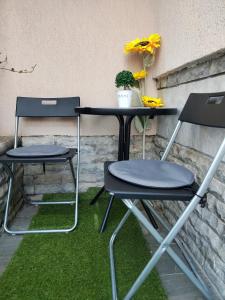 two chairs and a table on a patio with grass at VINI studio with private parking in Skopje