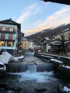 mały strumień wody w mieście z budynkami w obiekcie Chalet Sweet Mountain w mieście Ponte di Legno