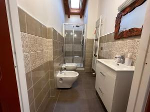 e bagno con servizi igienici, lavandino e doccia. di NG Guest House il RIS a Sassari