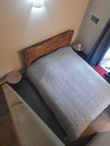 Bett mit einem Kopfteil aus Holz in einem Zimmer in der Unterkunft LA PLANTATION in Saint-André