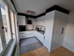 a kitchen with white cabinets and a large window at Luxury Apartment EMAS Old town Sarajevo dream view in Sarajevo