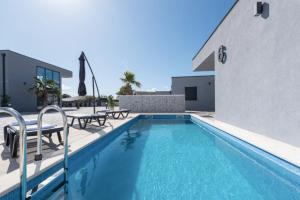 a swimming pool with tables and chairs next to a building at More Exclusive Villas and Spa in Vir