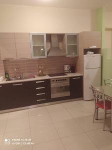 uma cozinha com um fogão, um frigorífico e uma mesa em Family House em Agios Nikolaos