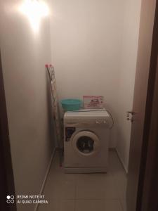 uma pequena casa de banho com uma máquina de lavar roupa num quarto em Family House em Agios Nikolaos