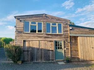 a wooden house with a garage in front of it at Countryside Retreat Loft Apartment in Llancillo