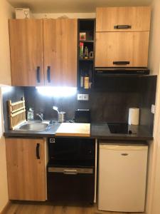 cocina con fregadero y lavavajillas negro en Appartement Alpe-d'Huez 4 Personnes en L'Alpe-d'Huez