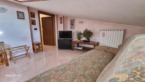 Una sala de estar con una cama y un televisor. en Lilly's House, en Castel di Sangro