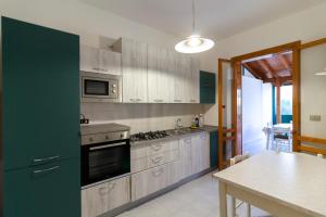 une cuisine avec des armoires en bois et une table à l'intérieur dans l'établissement La casa di Bea - Torre dell'orso, à Torre dell'Orso