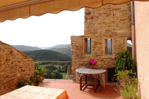 a stone building with a table and flowers on a patio at Casa Rural Vilaspasa, alquiler integro in Gotarta