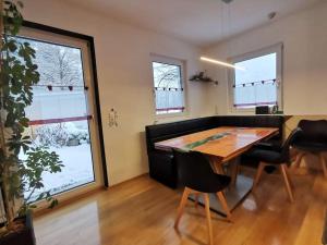 uma sala de jantar com mesa, cadeiras e janelas em Ferienhaus mit 4 Zimmer am Lech em Reutte