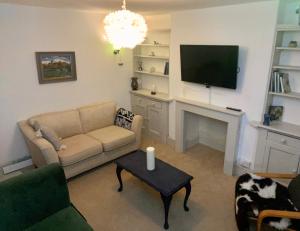- un salon avec un canapé et une télévision dans l'établissement The Dragonfly BNB, Glastonbury, à Glastonbury