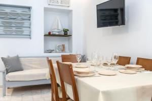 a dining room with a white table and chairs at PG Houses in Kalloni Village - PHouse in Kalloni Tinou