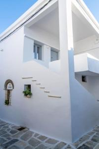 un edificio blanco con escaleras y ventana en PG Houses in Kalloni Village - PHouse en Kalloni Tinou