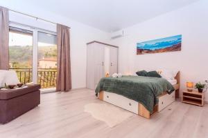 a bedroom with a bed and a large window at Villa Marietta Equino in Donje Sitno +19 photos