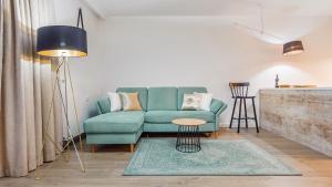 a living room with a blue couch and a table at Apartament Lux Tukan A315 Nadmorskie Tarasy - Holiday City in Kołobrzeg
