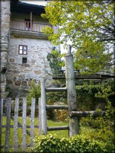 une clôture en bois devant un bâtiment en pierre dans l'établissement Casa da Laxa, à Magros