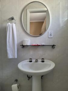 uma casa de banho com um lavatório branco e um espelho. em Hotel Estação Express em Curitiba