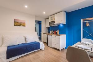 1 dormitorio con paredes azules, 1 cama y 1 mesa en Plancy Beds Châlons en Châlons-en-Champagne