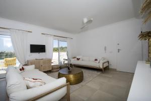 a living room with white furniture and a tv at 401 Villa Salemar in Salema