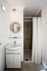 a white bathroom with a sink and a mirror at 401 Villa Salemar in Salema