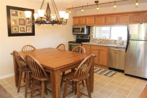 eine Küche mit einem Holztisch mit Stühlen und einem Kühlschrank in der Unterkunft Seven Springs 1 Bedroom Premium Condo, Ski In Ski Out condo in Champion
