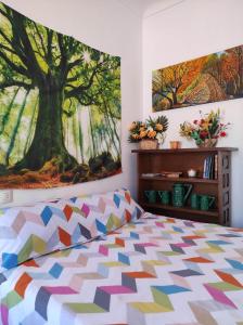1 dormitorio con una gran pintura de árbol en la pared en Casa Rural El Sendero, en El Burgo