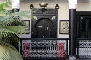 une porte noire dans une pièce ornée de plantes dans l'établissement Palais-Riad Razala & Spa, à Marrakech