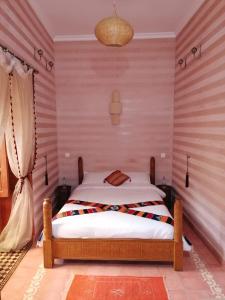 a bedroom with a bed in a room with striped walls at DAR MAR'OUKA , Maison d'hôtes in Marrakech