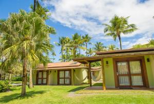 una casa con palmeras delante en Cana Brava All Inclusive Resort, en Olivença