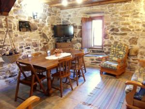een eetkamer met een houten tafel en stoelen bij Casa da Laxa in Magros