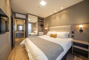 une grande chambre avec un grand lit blanc dedans dans l'établissement Chateau du Golden Lagheto, à Gramado 9 autres photos