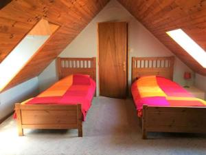 two beds in a attic room with wooden ceilings at La Maison Tournesol - 3 bedroom house with large garden near Saumur in Saint-Martin-de-la-Place