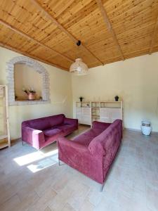 - un salon avec deux canapés violets dans l'établissement La Casa di Argia, à Bugnara