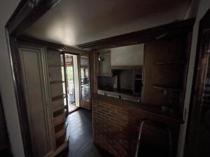 a room with a kitchen with a microwave and a door at charmante maison avec 4 chambres et parking fermé in Nevers