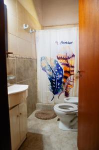 y baño con aseo y cortina de ducha. en Cabañas Huidun en San Rafael