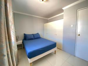 a small bedroom with a blue bed and a window at Benito Home in Tera Kora
