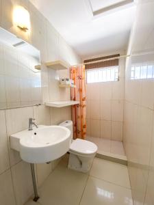 Benito Home في Tera Kora: حمام أبيض مع حوض ومرحاض