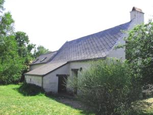 an old white building with a black roof in a field at La Maison Tournesol - 3 bedroom house with large garden near Saumur in Saint-Martin-de-la-Place