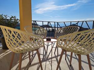 3 sillas y una mesa en el balcón en Sunset view guest house, en Ilindentsi
