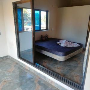 een spiegel in een slaapkamer met een bed in een kamer bij Shobhnath Home Stay in Harnai