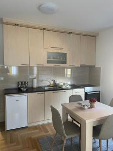 a kitchen with a table and a table and chairs at Apartman Arcobaleno in Vrnjačka Banja